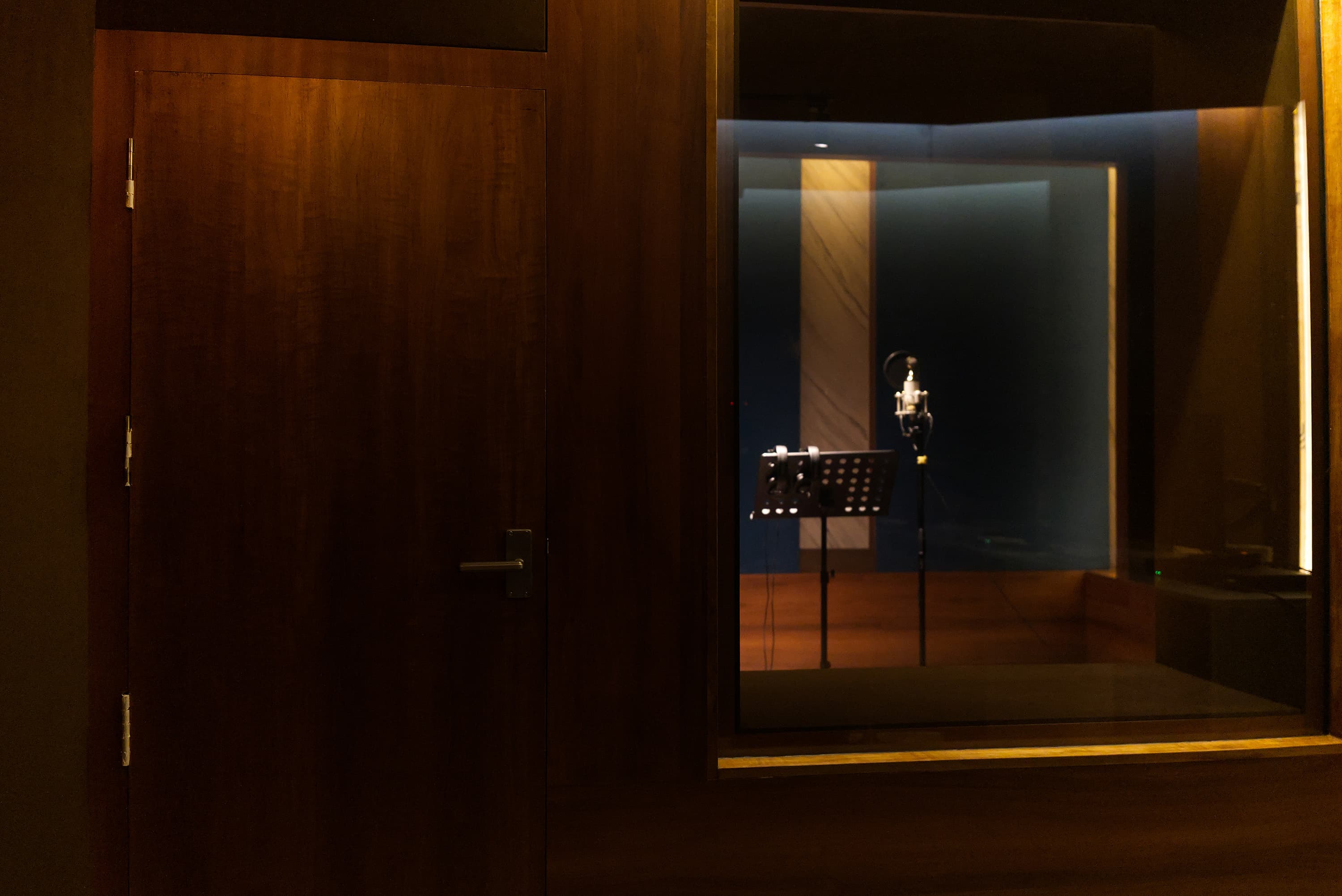 View into a recording booth at Abylon studio, Kerala, with mic stand and warm ambient lighting